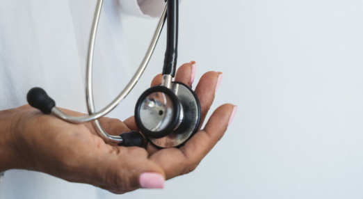 Hand holding black and silver stethoscope
