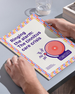 Ringing the alarm - someone's hands are poised to open a printed copy of the 'Ringing the alarm' report